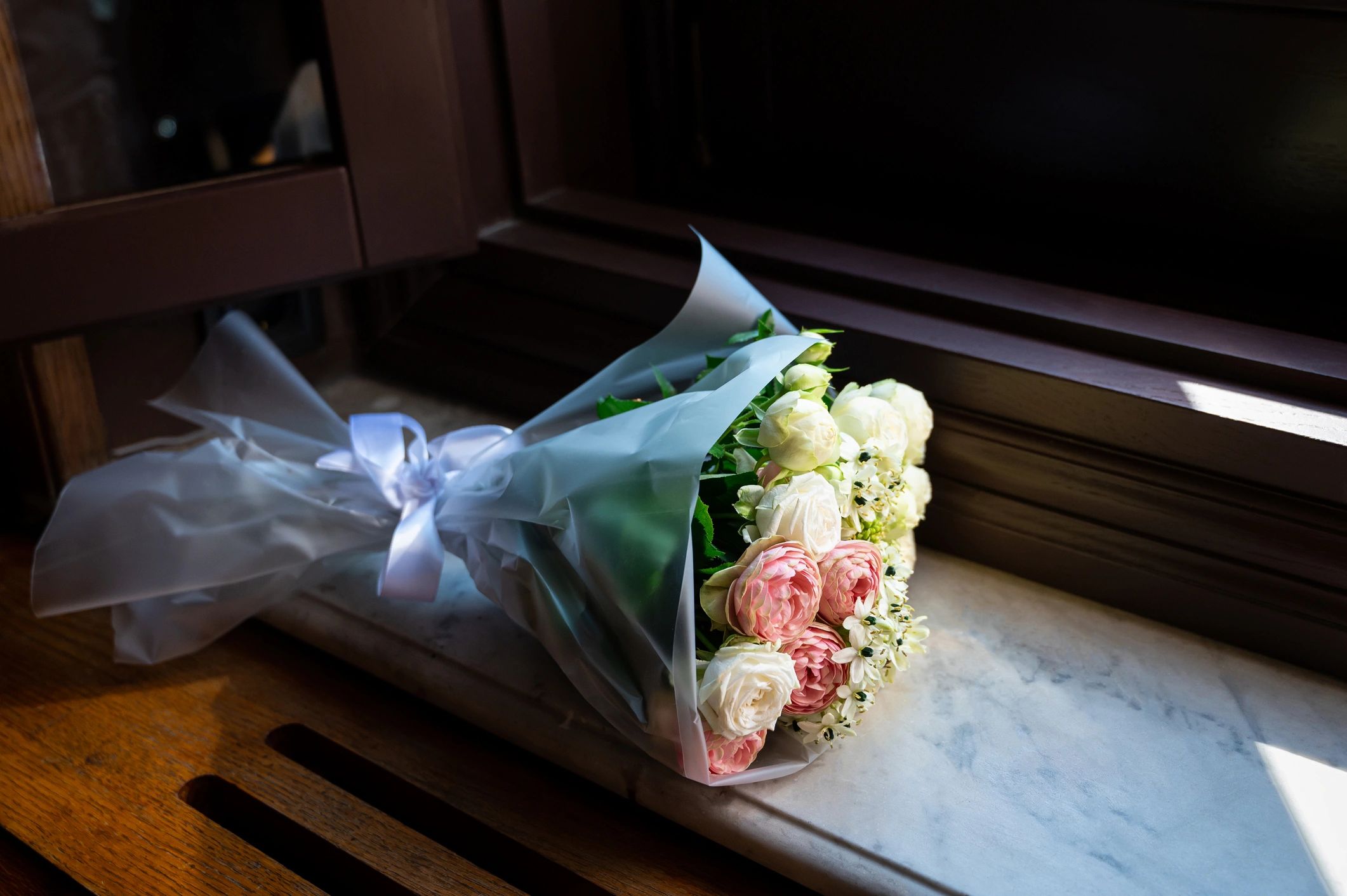 Delicate bouquet of pink and white roses in sunlight