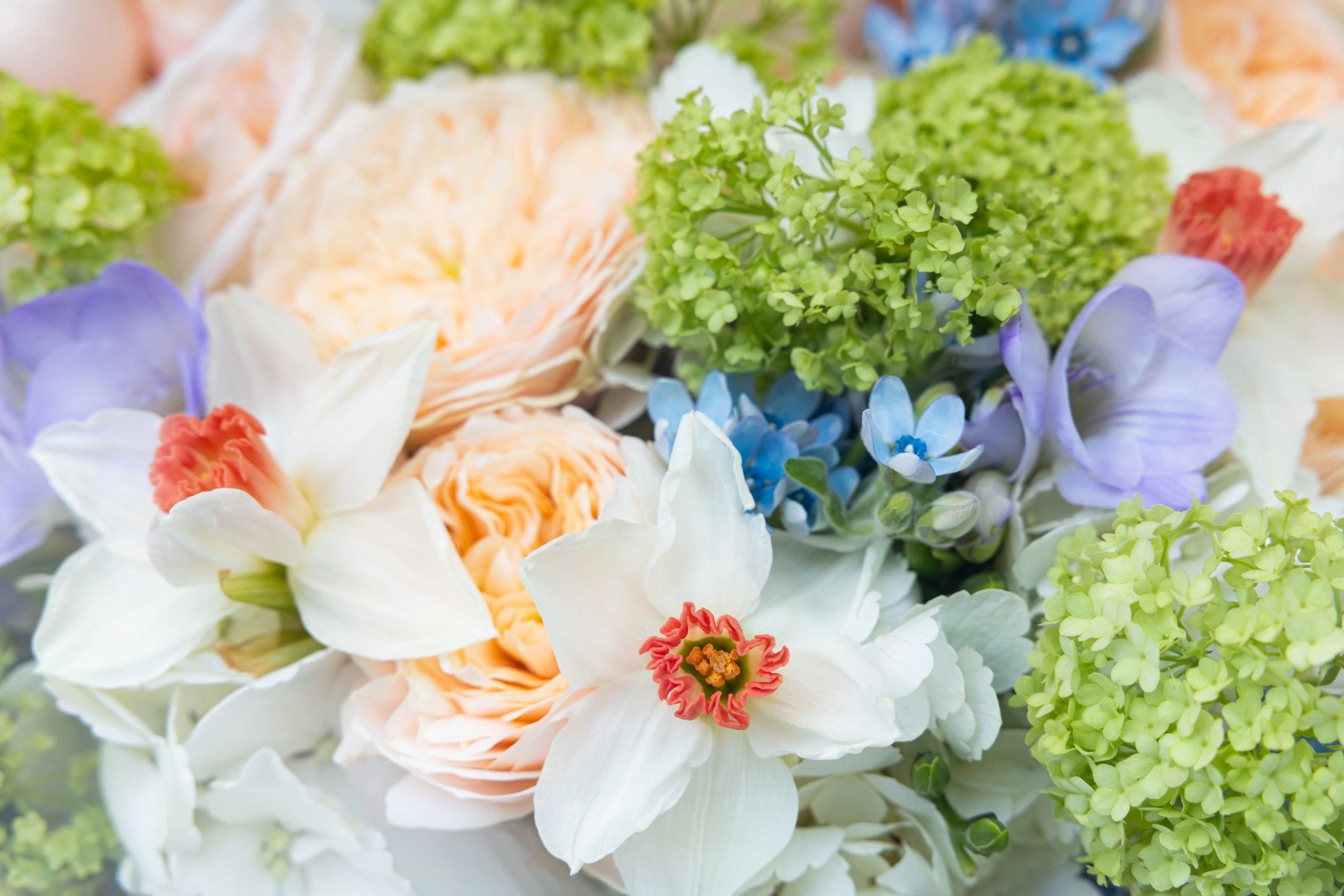 Spring flower bouquet with white daffodils and peach roses